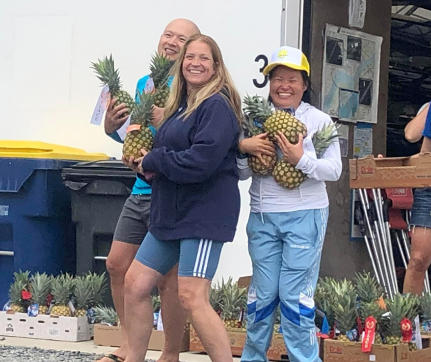 Photo of 3 people carrying pineapples